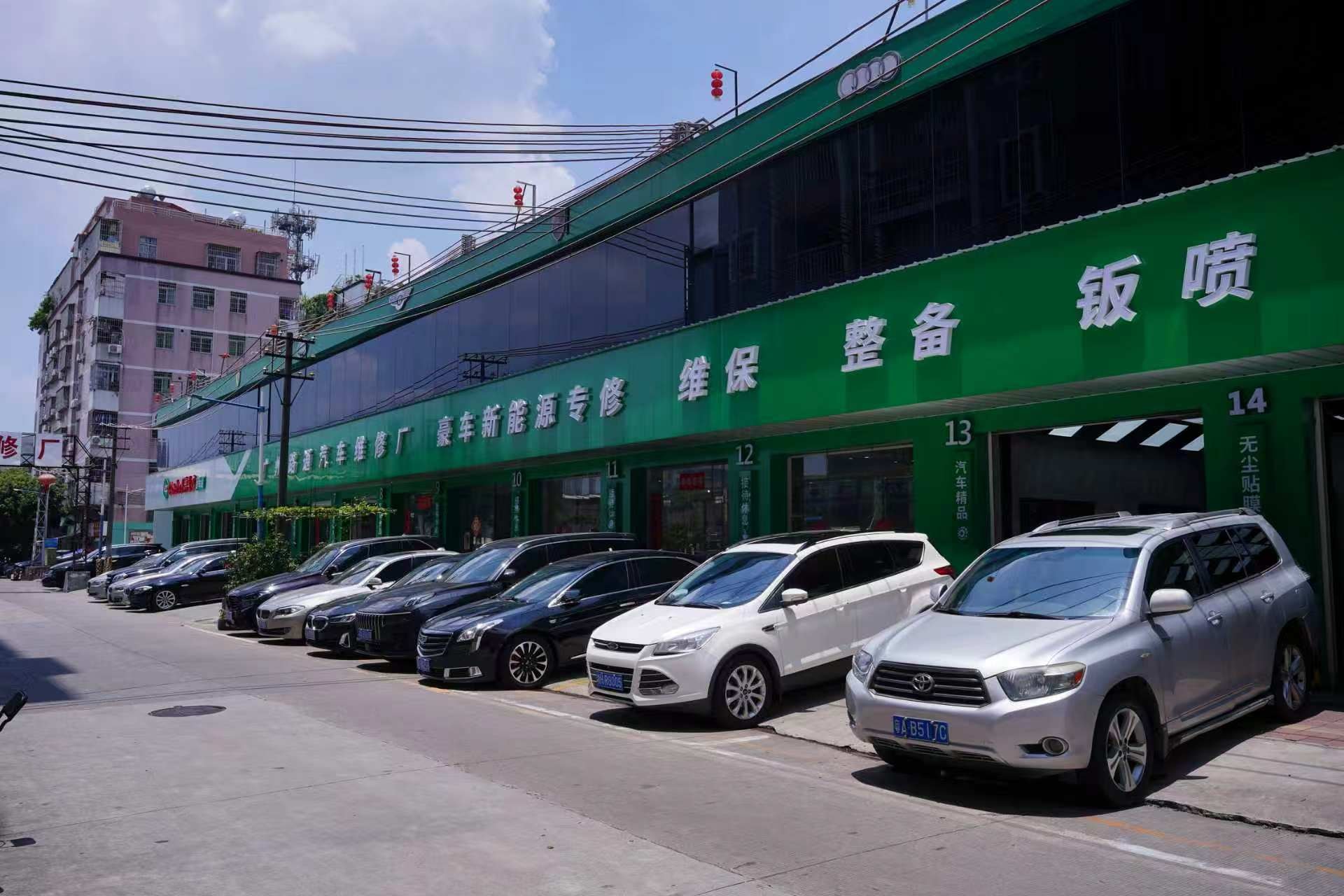 路通维修厂门店外观,绿色招牌与门前车辆