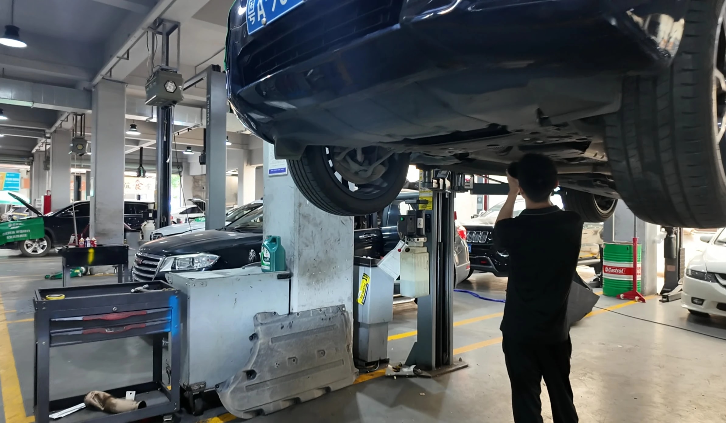 路通技师在举升车辆下进行检查作业